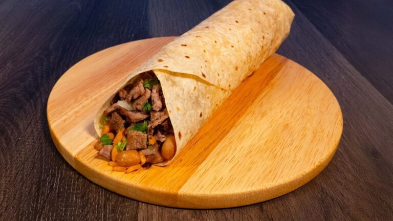 burrito with a side of tortilla chips, guacamole, and a fountain drink