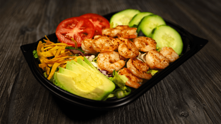 delicious shrimp salad loaded with variety of vegetables, and chips.